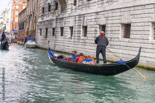 Gondoliers helping tourists exploring city, Venice © jovannig