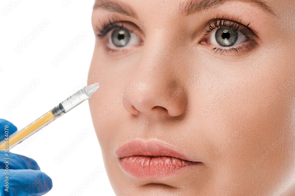 cropped view of plastic surgeon in latex glove holding syringe near attractive patient isolated on white cropped view of plastic surgeon in latex glove holding syringe near attractive patient isolated on white