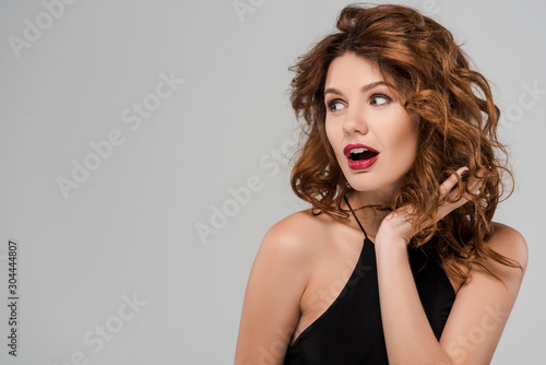 surprised young woman looking away isolated on grey