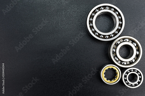 Fotografía Ball bearing lying on a black background with copy space on the left side, flat view from above