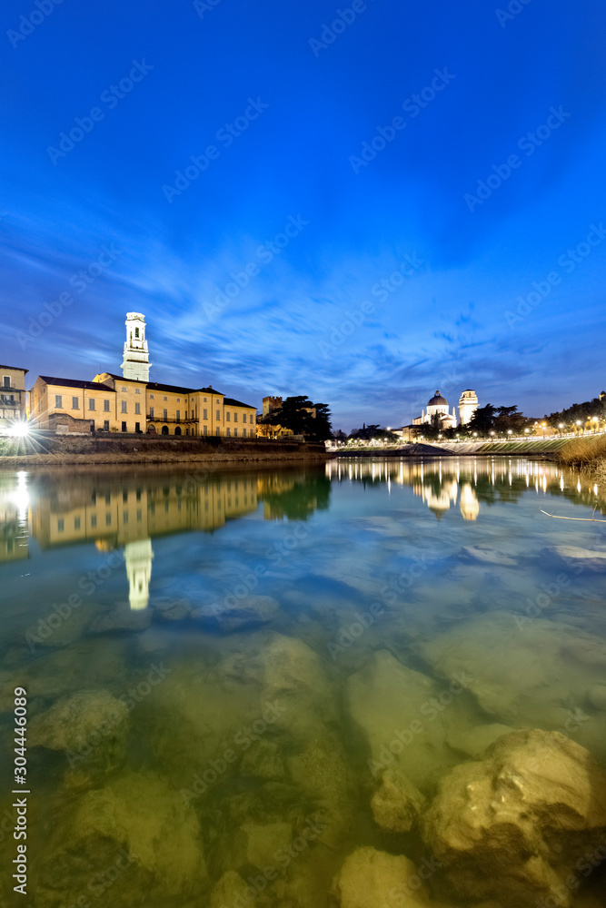 The river Adige flows in the city center of Verona. On background the Santa Maria Matricolare Cathedral and the San Giorgio in Braida Church. Verona, Veneto, Italy, Europe.
