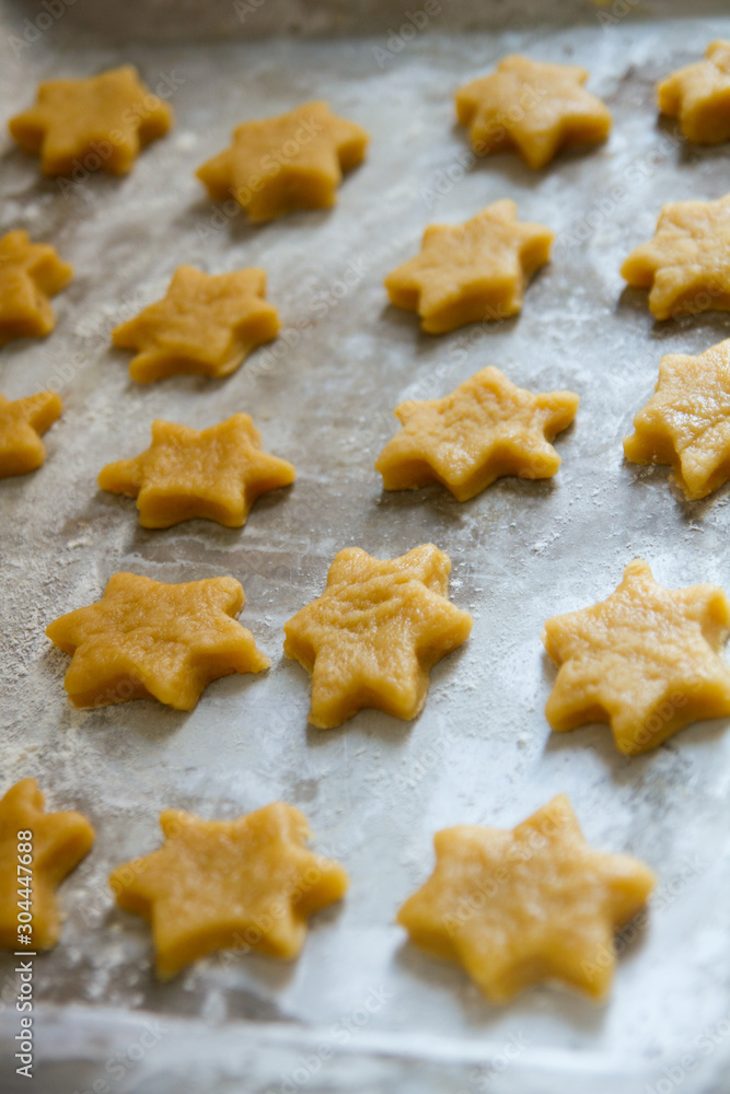 Baking christmas ginger cookies: cutted stars on the pan ready to be baked