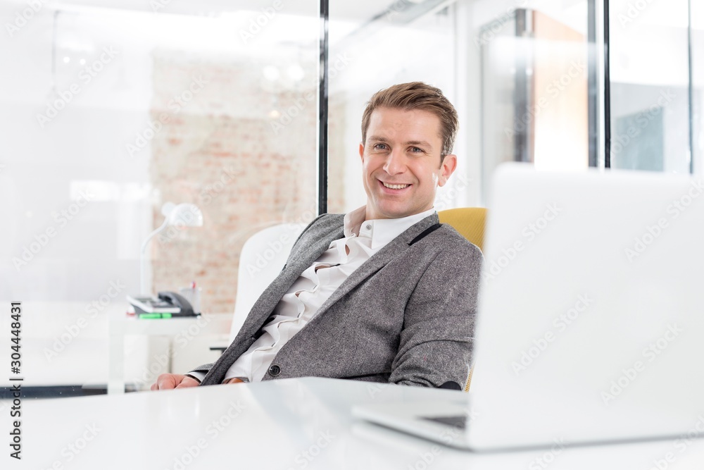 Attractive businessman sitting and relaxing in his office