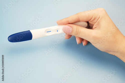 Closeup female hand with pregnancy test. Negative pregnant result.