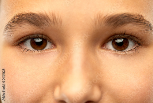 beauty, vision and people concept - close up of teenage girl face with brown eyes