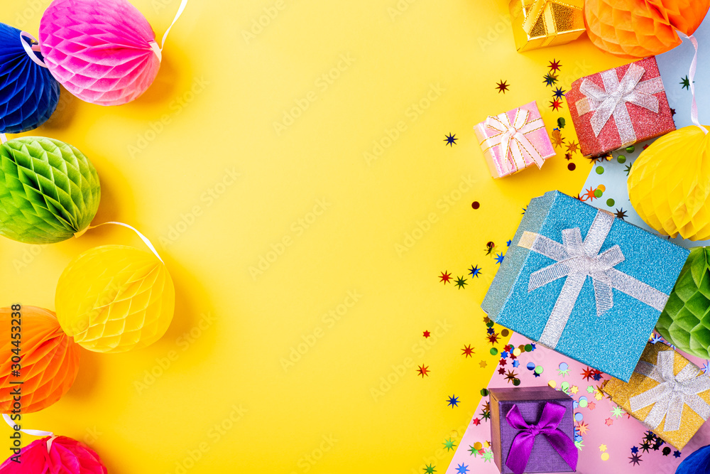 Holiday frame composition with gifts and decoration on yellow background with copy space for text. Festive celebration concept for postcard or invitation, Top view, flat lay.