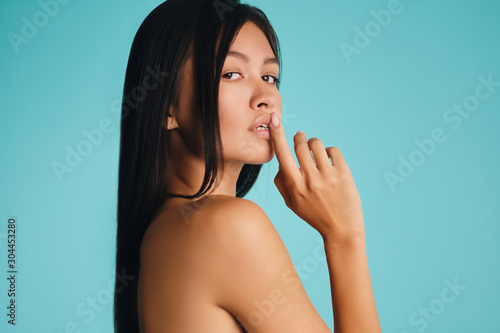 Attractive sexy Asian brunette girl confidently looking in camera over colorful background isolated