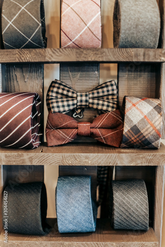 Ties and bow tie lie on wooden shelves
