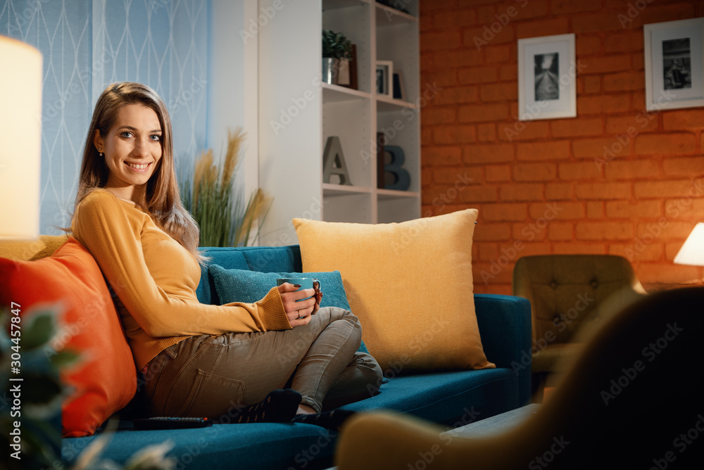 Young woman sitting on the sofa at home and posing Young woman sitting on the sofa at home and posing