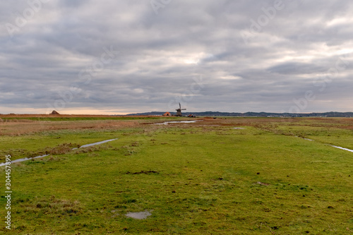 Harger and Pettemer polder with a windmill on the horizon under a cloudy sky