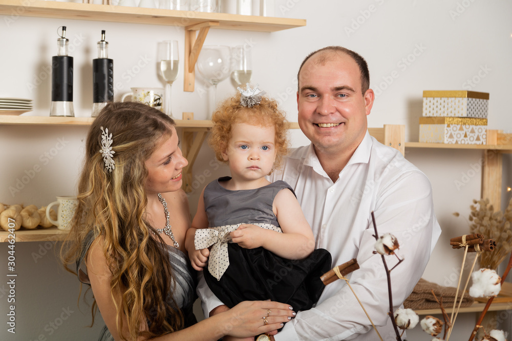 Happy family with a child in the kitchen in the New Year. Happy family with a child in the kitchen in the New Year.