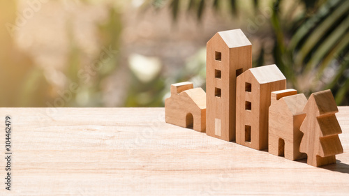 Model of wooden houses ,apartment and tree on wooden table and natural background, Image for community or real estate business investment advertisement concept,
