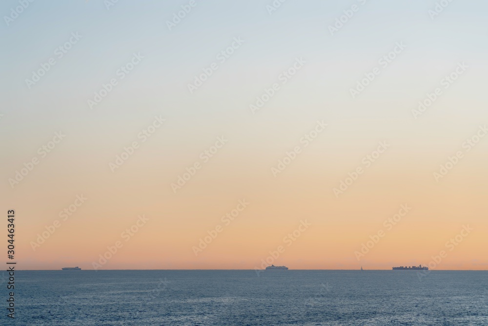 Sea view at sunset with 3 vessels far away , minimalistic look