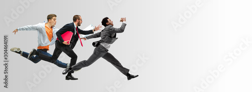 Happy office workers jumping and dancing in casual clothes or suit with folders on white. Ballet dancers. Business, start-up, working open-space, motion and action concept. Creative collage. Copyspace