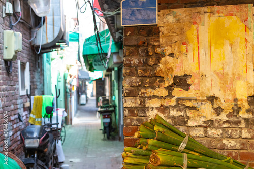 Brick wall and narrow alley in defocus. Blurred Narrow alley at colorful Asian street. Asian shopping street. © Mikhail