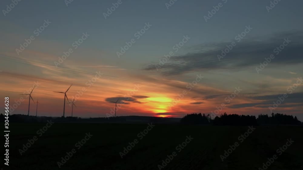 Colorful sunset in evening with wind turbines Colorful sunset in evening with wind turbines