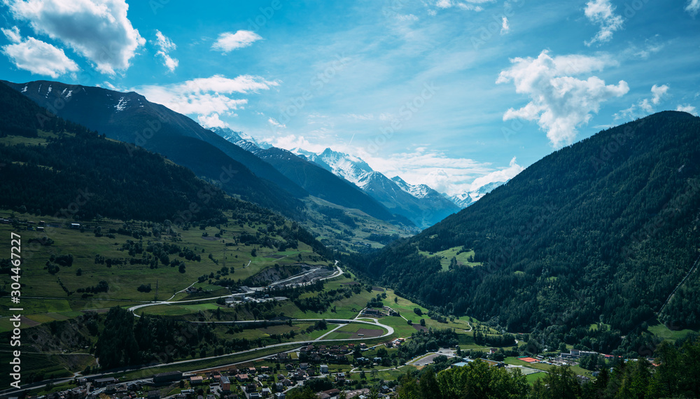 Beautiful view of idyllic Swiss alpine mountains scenery with meadows and snow capped mountain peaks on a beautiful sunny day with blue sky in springtime. Beauty world.