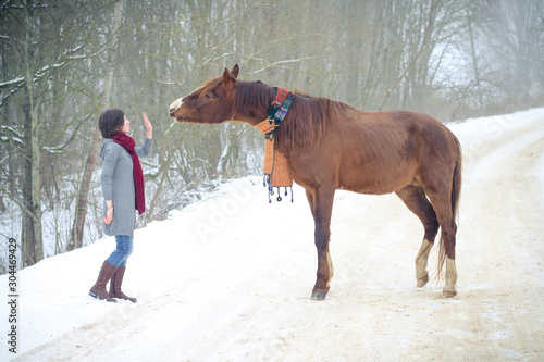 girl and red trakehner stallion horse with scarf in winter