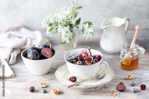 Cottage cheese with figs, berries, honey. Cup of coffee and coffee pot. Breakfast. Wooden table.