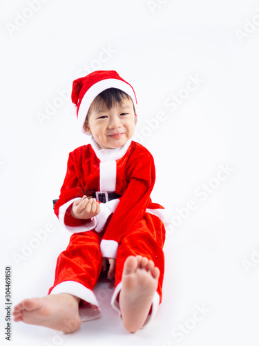 Asian boy is wearing a Santa costume to celebrate Christmas. White background