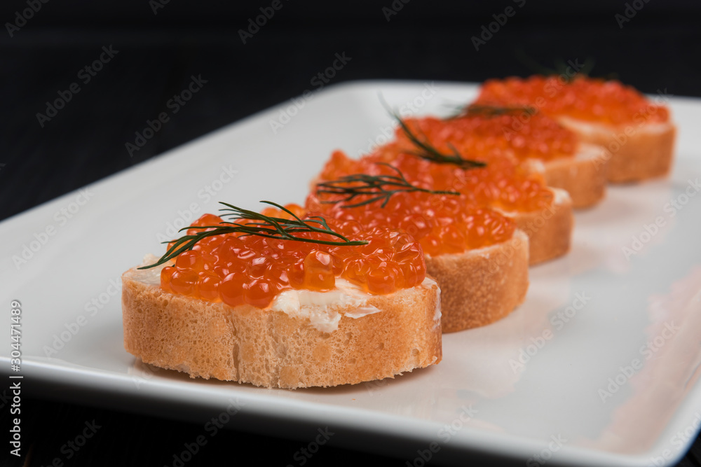 Sandwich with caviar and butter on a white plate. Sandwich with caviar and butter on a white plate.