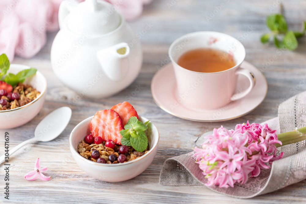 Spring Breakfast with granola and fresh strawberries and lychee and flowers on wooden background. Spring Breakfast with granola and fresh strawberries and lychee and flowers on wooden background.