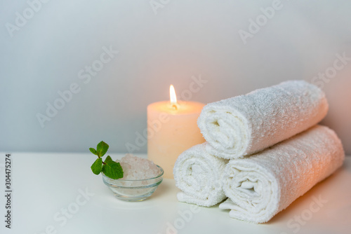 Recreation in SPA concept photo with candle, stack of towels and sea salt for bath.