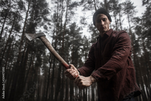  Lumberjack with the ax in the forest.Stylish lumberman getting ready for work. Hard iwork in the forest. Lumberjack chopping a tree. Lifestyle.  photo