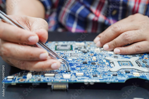 E-waste, technician repairing inside of hard disk by soldering iron. Integrated Circuit. the concept of data, hardware, technician and technology..
