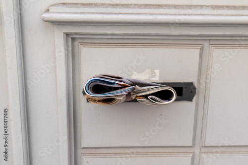 Many leaflets in mailbox filled with spam advertising paper