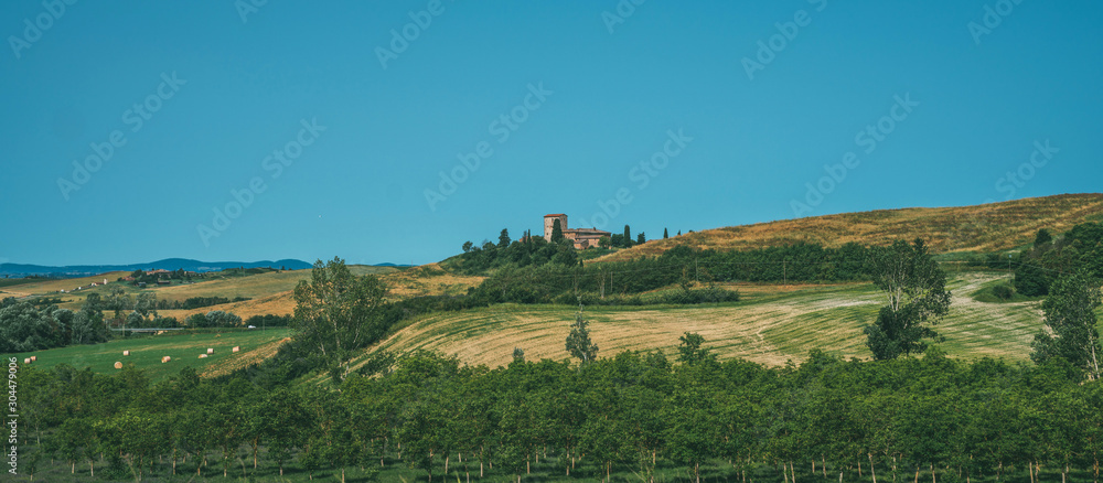 Beautiful landscape in Tuscany, Italy. Sunny fields. Agricultural area with wheat fields. Vintage tone filter effect with noise and grain.