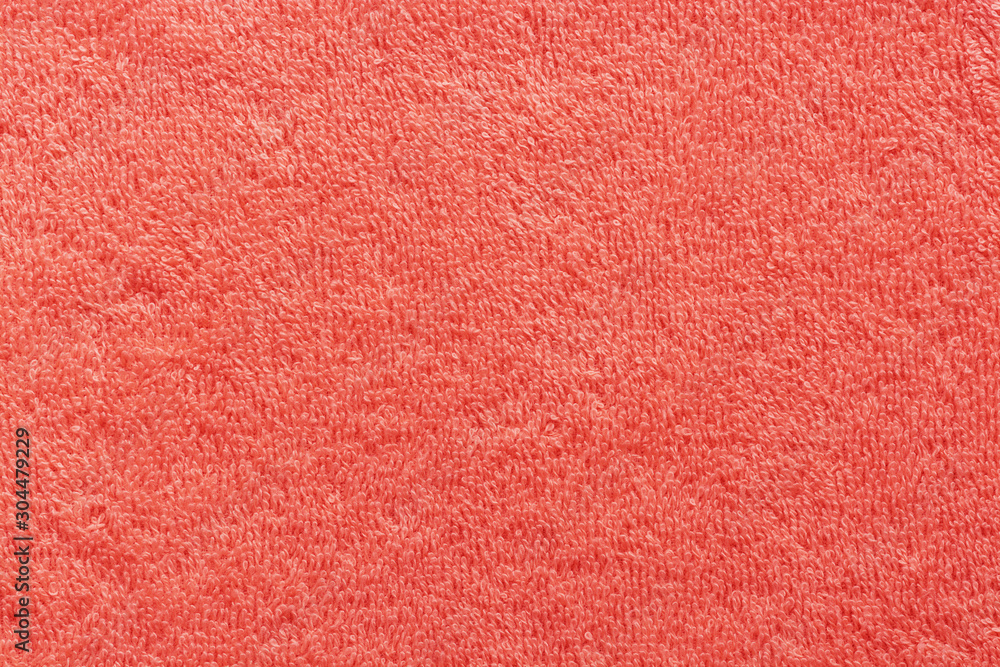 The texture of the terry towel is coral color. Abstract red soft fabric background. The texture of the terry towel is coral color. Abstract red soft fabric background.
