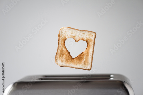 Heart shaped on roasted toasted bread in a toaster. Breakfast preparation on Valentine's Day. symbol sign of love. Concept