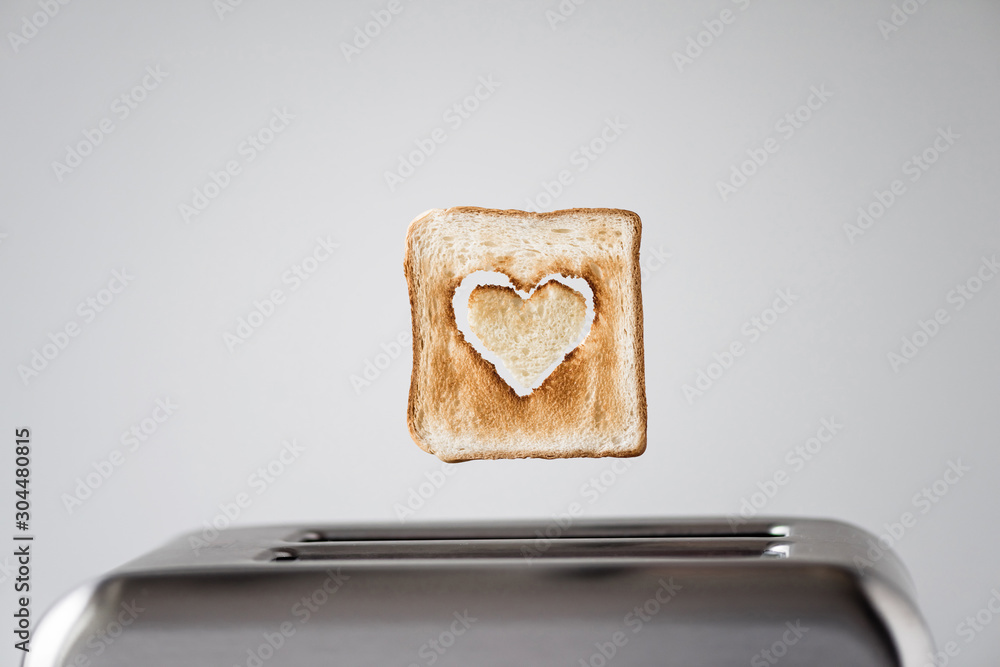 Heart shaped on roasted toasted bread in a toaster. Breakfast preparation on Valentine's Day. symbol sign of love. Concept