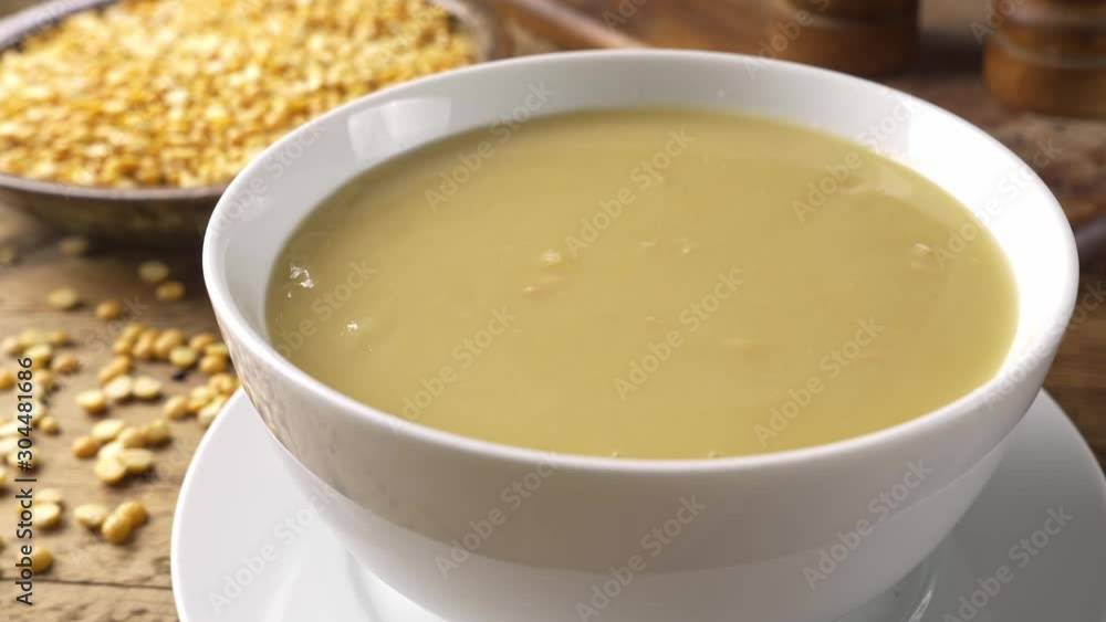 Spoon dipping into a hot bowl of French Canadian style yellow pea soup. Spoon dipping into a hot bowl of French Canadian style yellow pea soup.