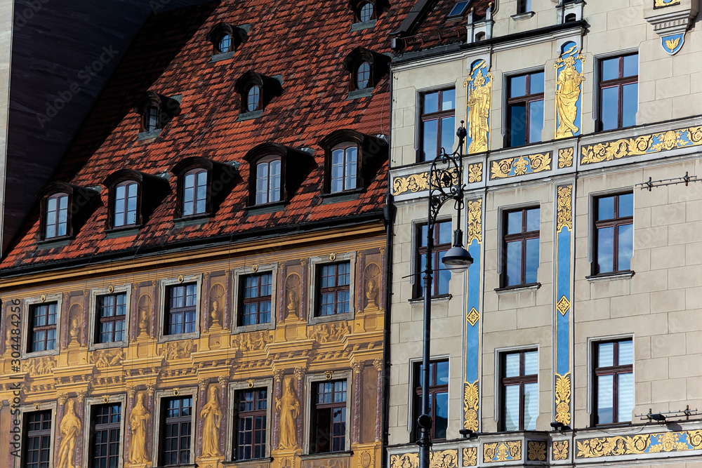 Painted facades of the famous historical buildings: House of the Seven Electors 1672 (left) and House under the blue sun (right) in the main market square of Wroclaw