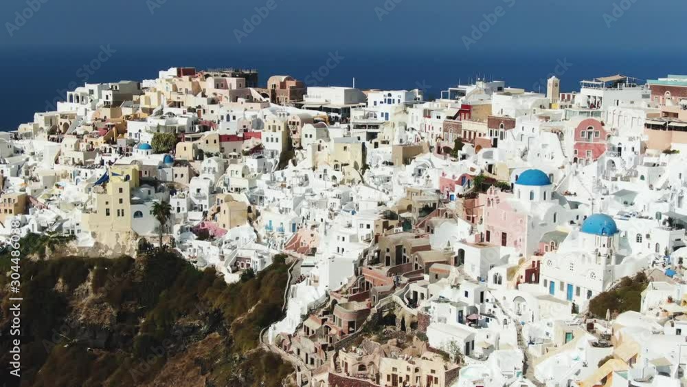 Flying above Santorini Island with iconic white and blue buildings in Greece Flying above Santorini Island with iconic white and blue buildings in Greece