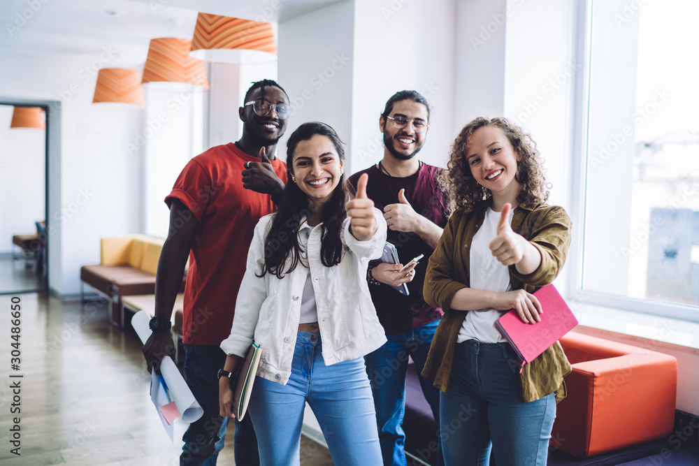 Obraz premium Successful young students showing thumbs up