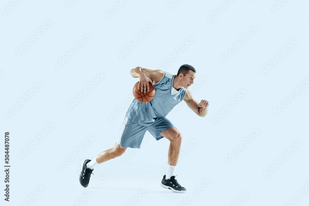 Winner. Young caucasian basketball player of team in action, motion in jump isolated on blue background. Concept of sport, movement, energy and dynamic, healthy lifestyle. Training, practicing.