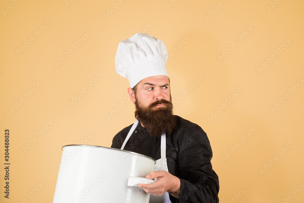 Cooking, culinary, food, profession and people concept. Cooking pot, saucepan, casserole. Male chef cook holds big pot. Cook man in apron holds saucepan in kitchen. Cookware, dinnerware, kitchenware.