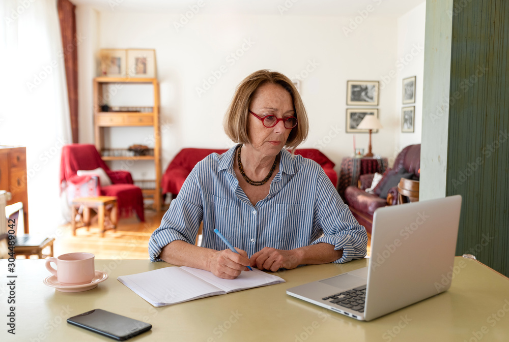 Middle age senior woman working at home using computer Middle age senior woman working at home using computer