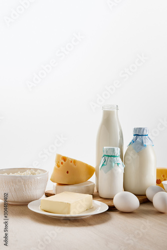 various fresh organic dairy products and eggs on wooden table isolated on white