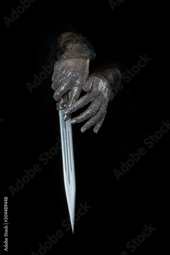 Fototapeta Naklejka Na Ścianę i Meble -  beautiful woman hands with glitter holding a sword close up