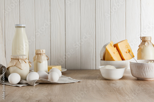 delicious fresh dairy products and eggs on white wooden background
