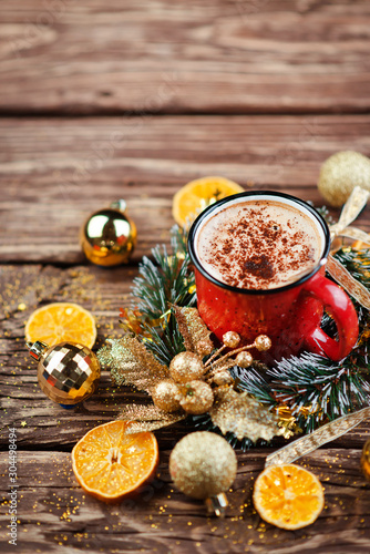 Christmas composition. Red Cup with cappuccino coffee over wooden background. Close-up with space for text.