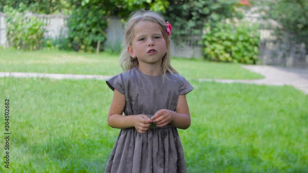 smiling little girl in summer,little girl with beautiful long hair in the summer sings in the yard smiling little girl in summer,little girl with beautiful long hair in the summer sings in the yard