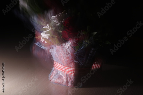 Vibes, the spirit of a bouquet, aroma, soaring over multi-colored bright flowers. A bouquet shot with a long exposure on a dark background and blurred in space.ht flowers.