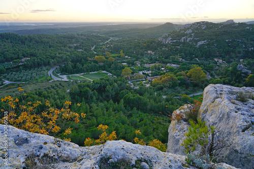 Sunset view of the Alpilles valley with green olive tree groves below the historic fortified village Les-Baux-de-Provence, in Bouches du Rhone, Provence, France.