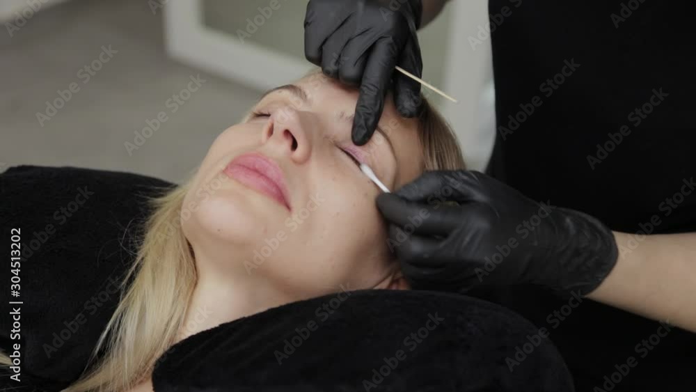 Professional beautician in beauty salon. Beautician does eyelash cleaning. Professional beautician in beauty salon. Beautician does eyelash cleaning.