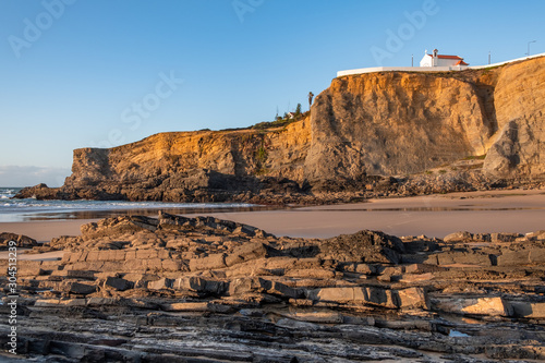 Beach of Zambujeira do Mar and small church on the cliff in Costa Vicentina, Portugal